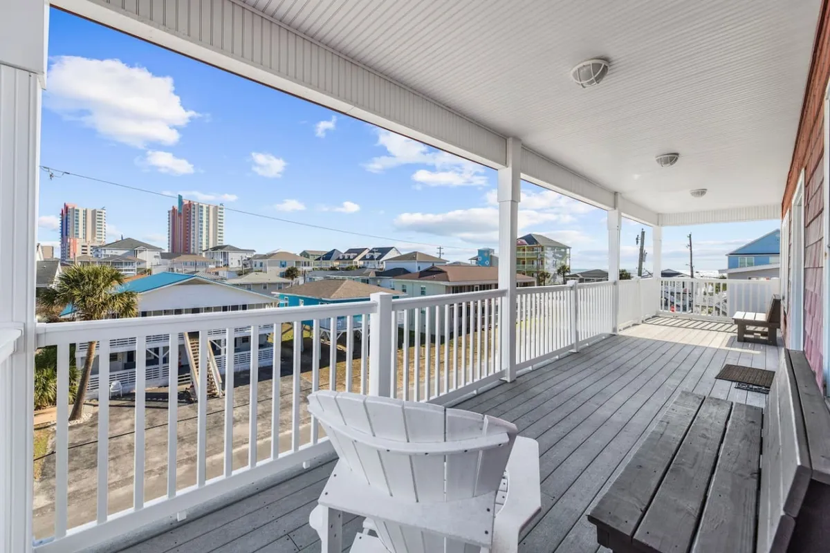 The image showcases an inviting outdoor seating area with comfortable furniture and a scenic view of nearby buildings under a clear blue sky. The setup is ideal for socializing, enjoying fresh air, or relaxing with drinks after a day exploring local wineries and restaurants.