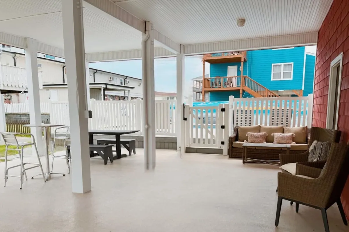 An outdoor seating area with a dining table enclosed by a fence, offering a casual yet comfortable setting for group meals or evening chats. The area is perfect for relaxing outdoors after returning from nearby entertainment venues.